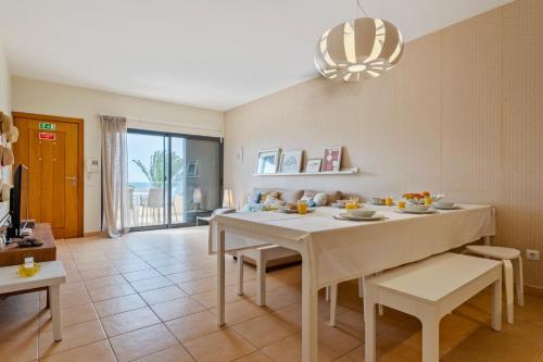 a dining room with a white table and chairs at Casa das Pedras Pretas - By WeHost in Porto Santo