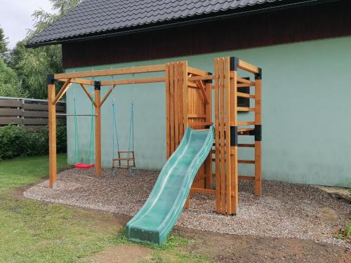 a playground with a green slide and a ladder at Chalupa Sluníčko in Čenkovice
