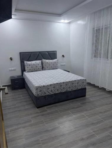 a bedroom with a bed in a white room at appart plage in M'diq