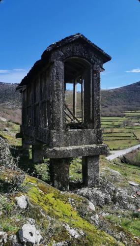 an old building on the side of a hill at Quarto Familiar do Januário in Bilhó