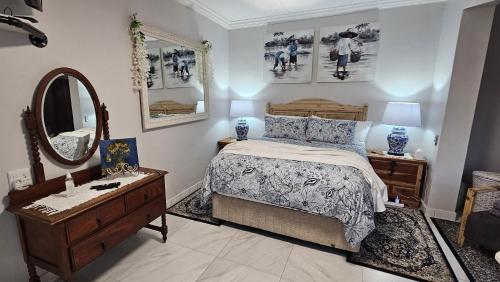 a bedroom with a bed and a dresser and a mirror at Upstairs R-4 Self Catering Unit in White River