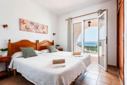 2 Betten in einem Schlafzimmer mit Meerblick in der Unterkunft Villa Esplendor in Son Bou