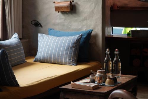 a bed with blue pillows and a table with bottles on it at Dechiu in Hoi An