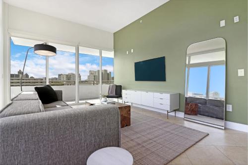 a living room with a couch and a flat screen tv at Roami at Sunny Isles in Miami Beach