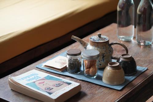 a table with a tray with jars and a book at Dechiu in Hoi An