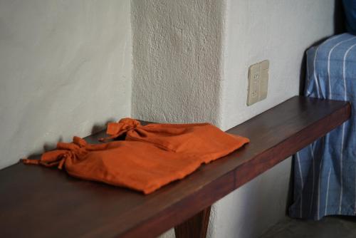 an orange shirt sitting on a wooden shelf in a room at Dechiu in Hoi An