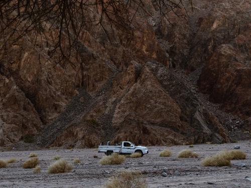 a white truck parked in a field near a mountain at Natural Lodge in Dahab