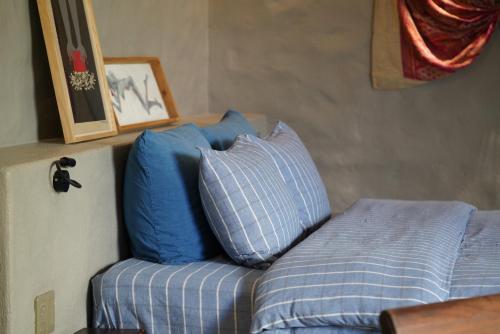 a bed with blue pillows on top of it at Dechiu in Hoi An