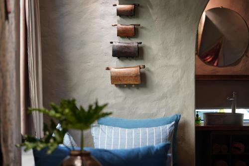 a room with a blue pillow and a wall with a mirror at Dechiu in Hoi An