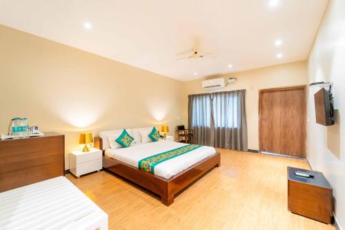 a hotel room with a bed and a television at Skazka beach resort in Mandrem