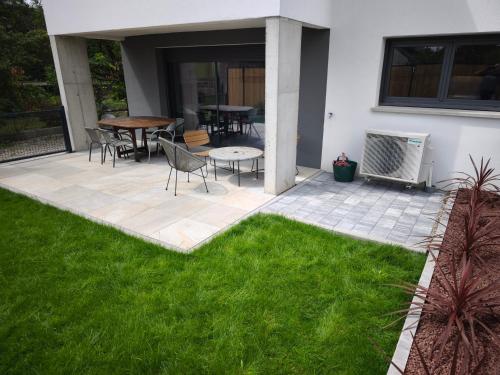 a patio with grass and a table and chairs at Près colmar 6 in Wolfgantzen