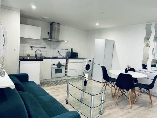 a living room with a couch and a table and a kitchen at Petit coin tranquille a 2 pas de strasbourg in Strasbourg