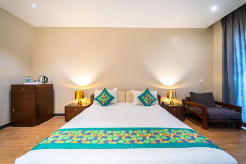 a bedroom with a large bed and a chair at Skazka beach resort in Mandrem