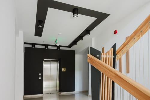 a hallway with black and white walls and stairs at City Center Accommodation - 108 in Reşiţa
