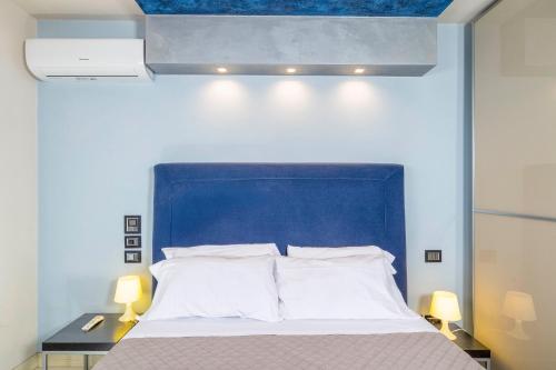a bed with a blue headboard in a room at La Maison de Elena Tuscany in Montepulciano
