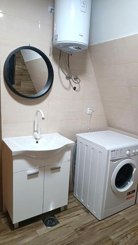 a bathroom with a washing machine and a sink at ZenFrame Cabin in Tarčin