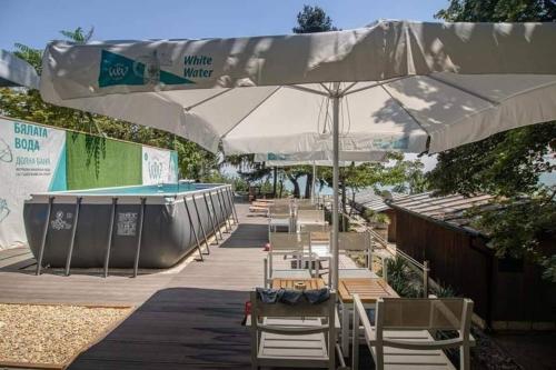 a row of chairs and umbrellas next to a pool at Bunaglows Panoramic Beach Village in Balchik