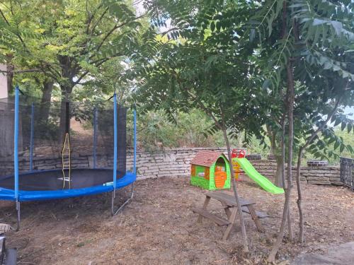 a playground with a slide and a trampoline at Bunaglows Panoramic Beach Village in Balchik
