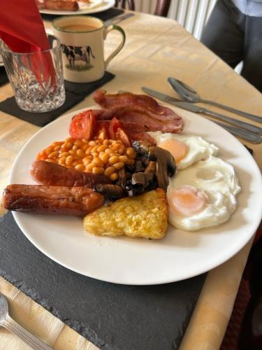 a plate of breakfast food with eggs bacon and beans at Enchmarsh Farm Byre in Church Stretton