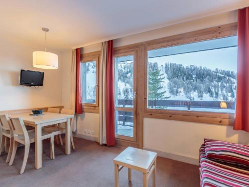 un salon avec une table et une grande fenêtre dans l'établissement Charmant appartement à La Plagne, 1 chambre, balcon, proche commerces - FR-1-351-213, à La Plagne Tarentaise