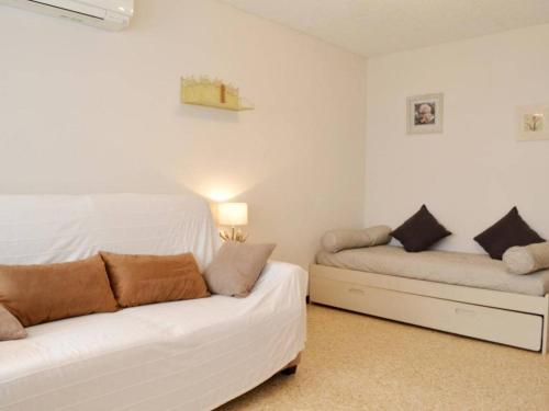une chambre avec deux lits blancs et un canapé dans l'établissement Studio Coquet 4 Couchages au Lavandou - Proche Plage, Parking Inclus, Commerces à Proximité - FR-1-251-299, au Lavandou
