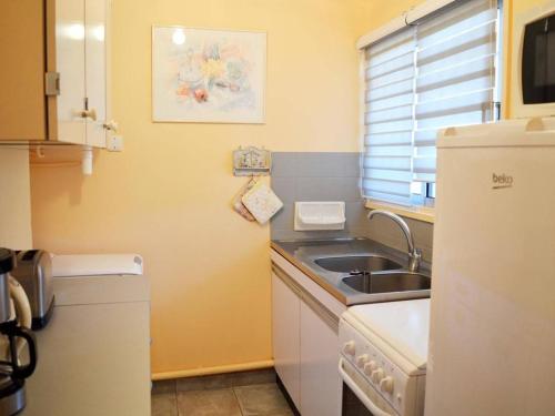 une petite cuisine avec un évier et un réfrigérateur dans l'établissement Studio Coquet 4 Couchages au Lavandou - Proche Plage, Parking Inclus, Commerces à Proximité - FR-1-251-299, au Lavandou