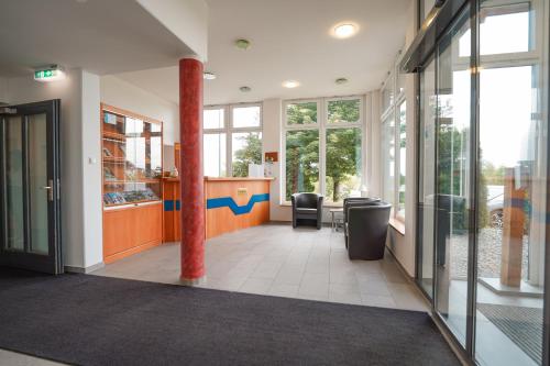 a lobby of a building with a pillar and a counter at Hotel Sonnenhof - Tante ALMA`s Sommerfrische in Sonnen