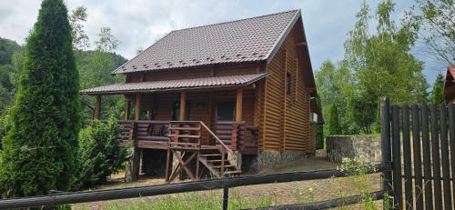 a small wooden house with a gate and a fence at Deep Forest 1 in Berehomet