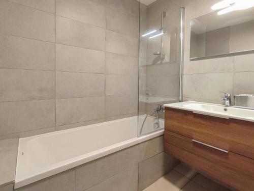 ein Badezimmer mit Badewanne, Waschbecken und Dusche in der Unterkunft Superbe chalet duplex 3* avec prestations hôtelières, pied de pistes, parking, wifi - FR-1-356-378 in Les Avanchers