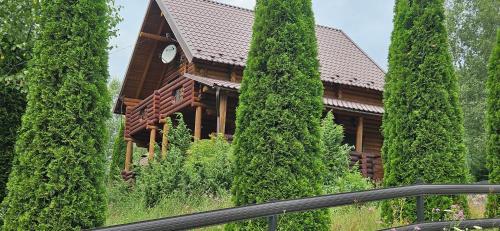 a house surrounded by tall trees and a fence at Deep Forest 1 in Berehomet