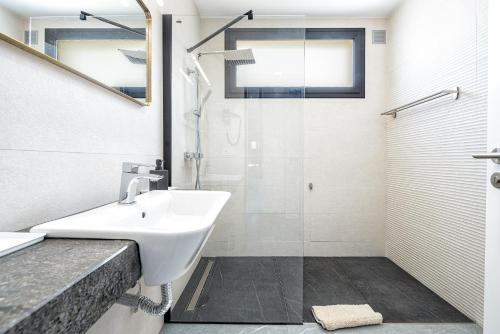 een badkamer met wastafel en douche bij villasroyale Silvermoon in San Bartolomé