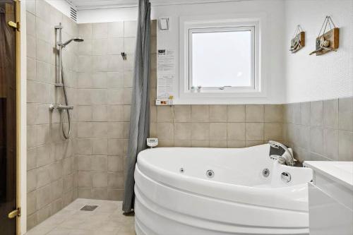 a white bath tub in a bathroom with a window at 1322-Snedsted-Lykkens-Hab-21 in Snedsted