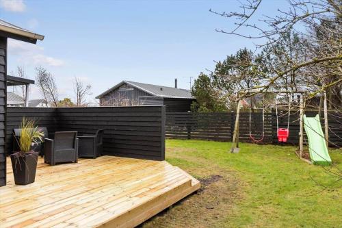 a backyard with a wooden deck and a swing at 1322-Snedsted-Lykkens-Hab-21 in Snedsted