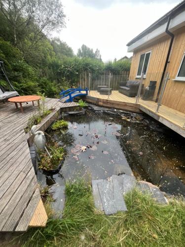 a pond with some koi in it next to a house at Luxurious Cottage on the River of Portree with Hot Tub! in Portree