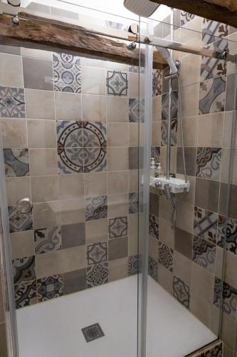 a shower with a glass door in a bathroom at Les Petits Cousins Du Québec - Chambres D’hôtes à Domme in Domme