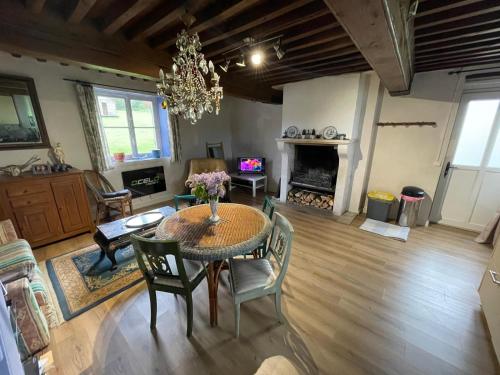 a living room with a table and chairs and a fireplace at Maison Bleue in Lavault-de-Frétoy