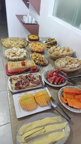 a table topped with lots of different types of food at Encanto da Praia hotel pousada in Natal