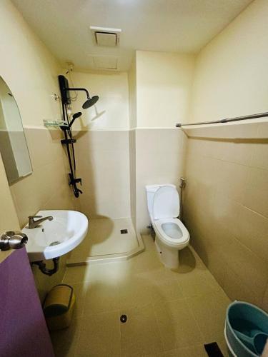 a bathroom with a white toilet and a sink at Charming Condo in Davao City Perfect for Families and Groups in Davao City