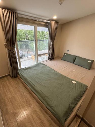 a bedroom with a bed and a large window at Dahill 196 Dalat in Da Lat