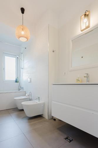 a white bathroom with a tub and a sink at City Center Accommodation 111 in Reşiţa