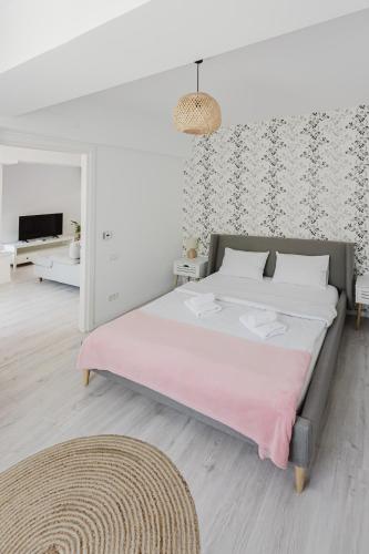 a bedroom with a large bed with a pink blanket at City Center Accommodation 111 in Reşiţa