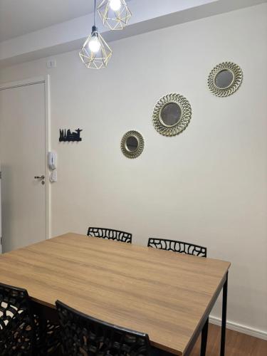 a dining room table with chairs and plates on the wall at 2 Quartos c Ar, Wi-Fi e conforto perto de tudo in Maringá