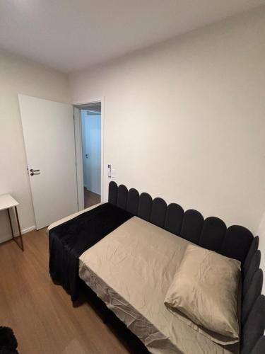a bedroom with a large bed with a black headboard at 2 Quartos c Ar, Wi-Fi e conforto perto de tudo in Maringá