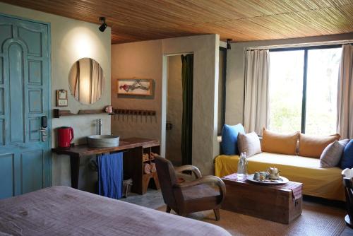 a room with a bed and a couch and a window at Dechiu in Hoi An