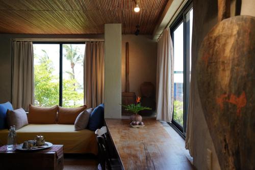 a living room with a couch and a large window at Dechiu in Hoi An