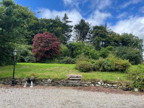 a park with a stone wall and a street light at Dernacally House and Spa in Carrigans