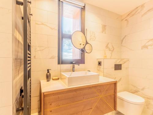 a bathroom with a sink and a mirror and a toilet at Appart chic avec SPA, parking et WIFI - Les Arcs 1800 - FR-1-352-96 in Arc 1800