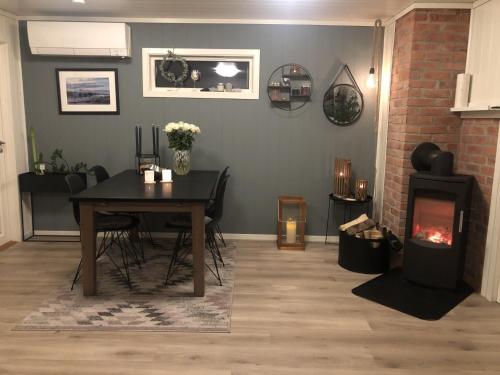a dining room with a table and a fireplace at Barnevennlig med strand og hage - Wifi in Søgne