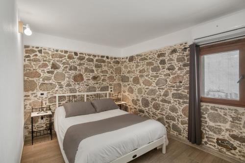 a bedroom with a bed and a stone wall at El Blanquizal A in La Aldea de San Nicolas
