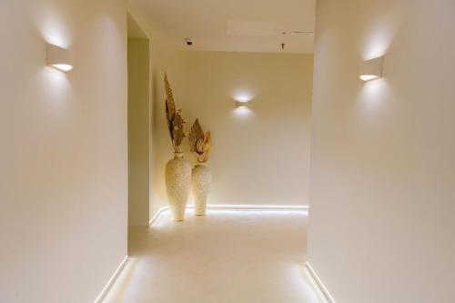 two vases in a room with white walls and lights at Iconic Mediterranean Hotel in Dhërmi